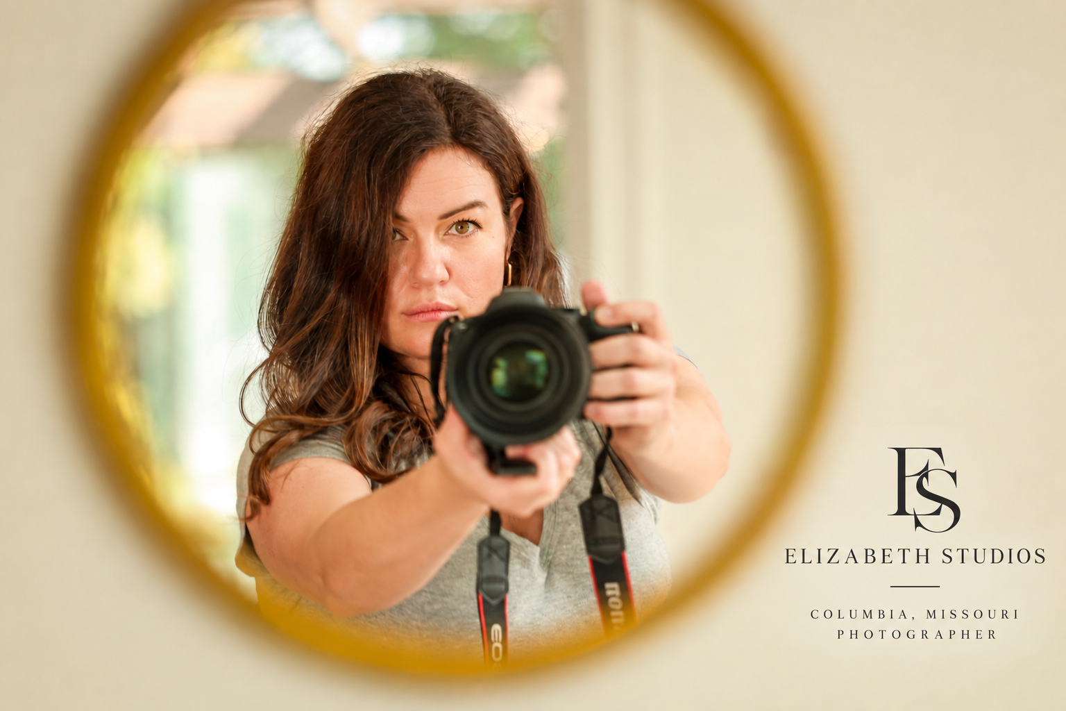Ashton of Elizabeth Studios with her camera, reflected in a gold-framed mirror